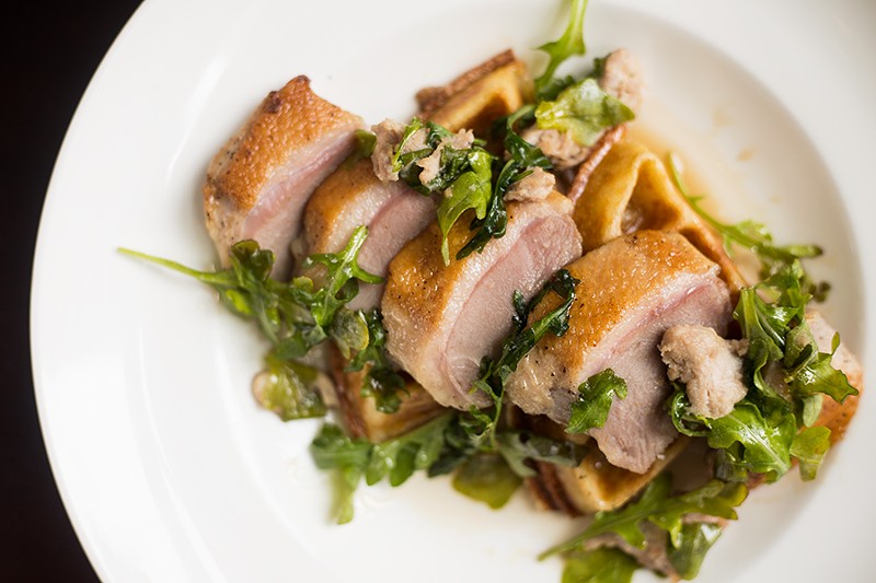 The maple-seared duck and waffles is served with bourbon maple syrup. - MABEL SUEN