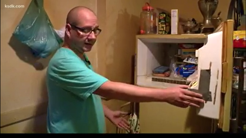 Adam Smith opens the freezer where, he says, a baby's body was kept for decades. - SCREENSHOT/KSDK