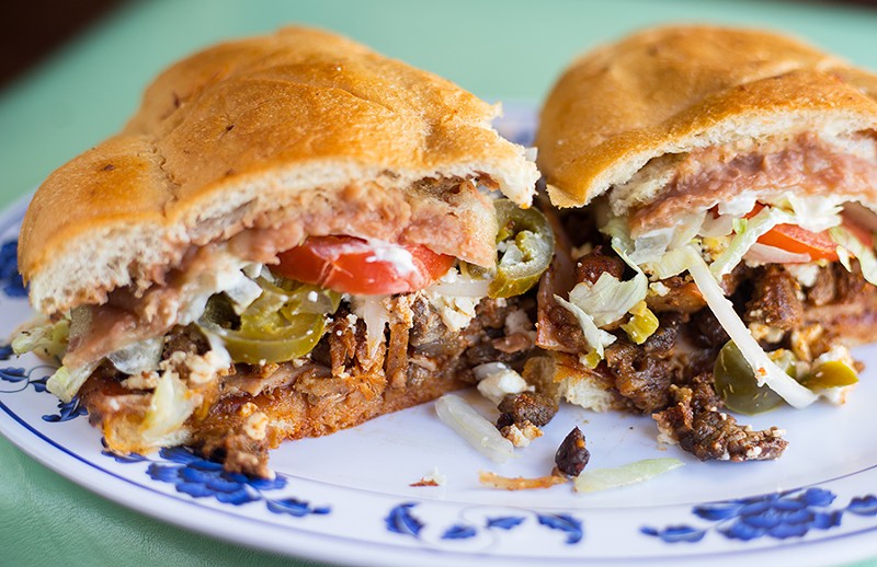 The Torta Cubana — featuring carne asada, ham and hot dogs — is a delicious mess. - MABEL SUEN