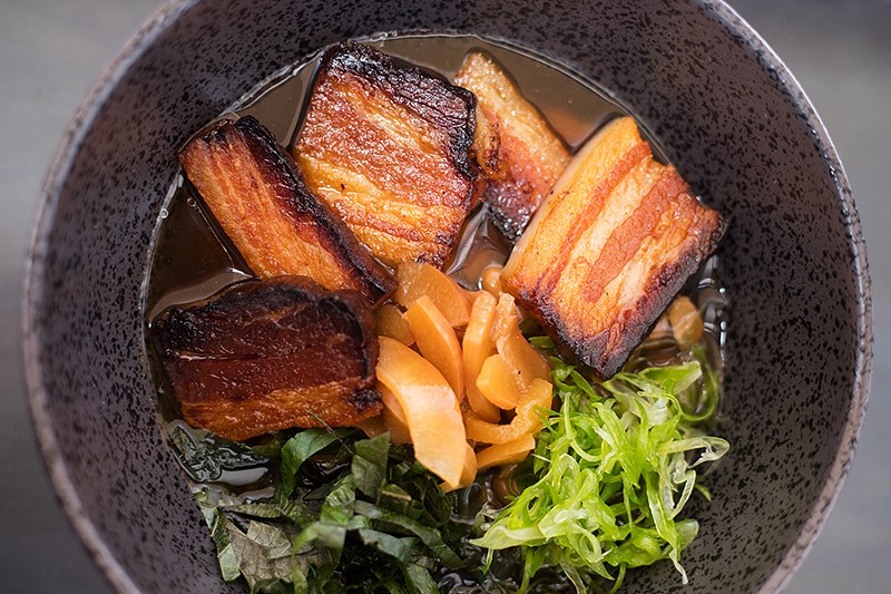 An updated version of pork and beans features braised bacon, Missouri pinto beans in foraged spicebush broth, peach miso, shiso and pickled peaches. - MABEL SUEN