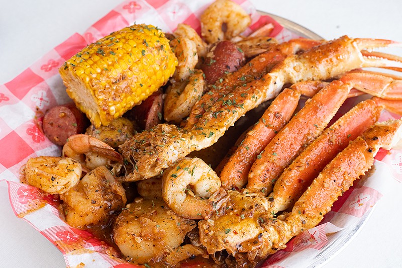 Spicy seafood boil with shrimp, crab legs, potatoes, sausage and corn. - MABEL SUEN