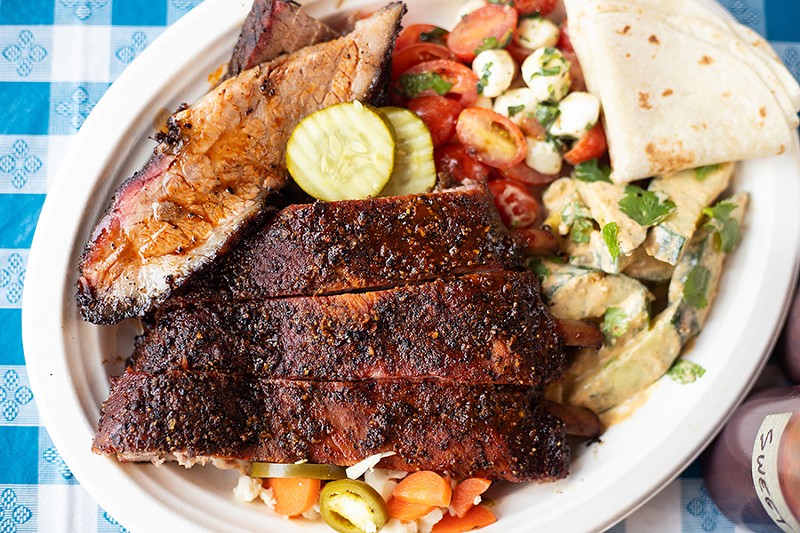 A two-meat combo platter with brisket, ribs, tomato with smoked mozzarella, tortillas and cucumber with poblano ranch. - MABEL SUEN