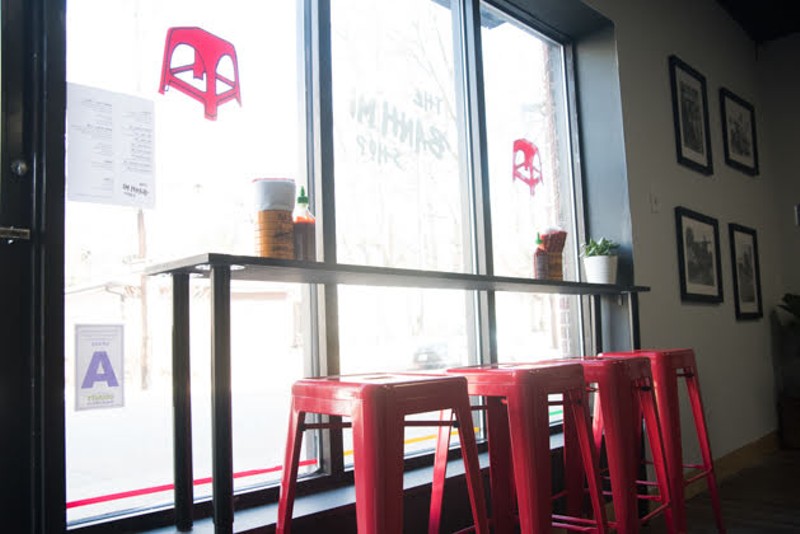 Red stools line the front window at the Bánh Mì Shop. - TRENTON ALMGREN-DAVIS