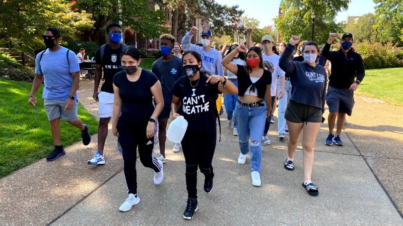 Vanessa Sarmiento (front left) and Ashlee Lambert (front right), lead the pack of student protestors down West Pine. - RILEY MACK