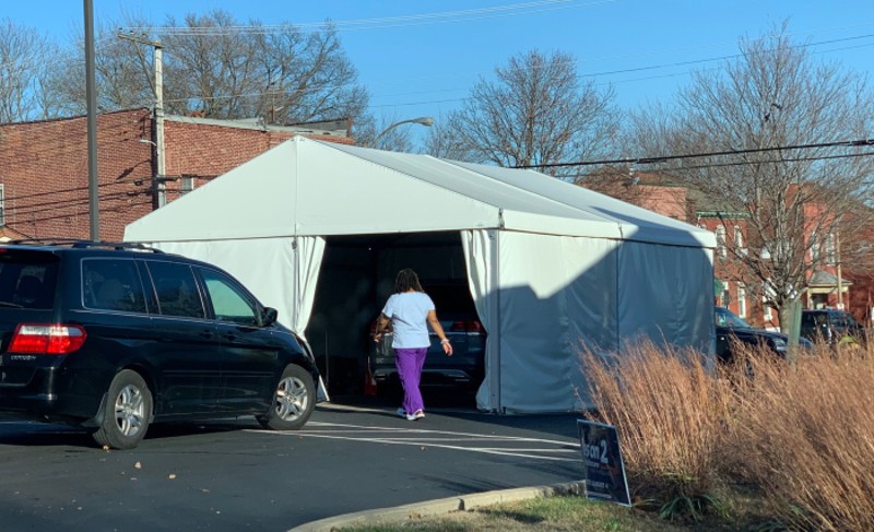A health-care worker enters a COVID-19 testing tent. - DOYLE MURPHY