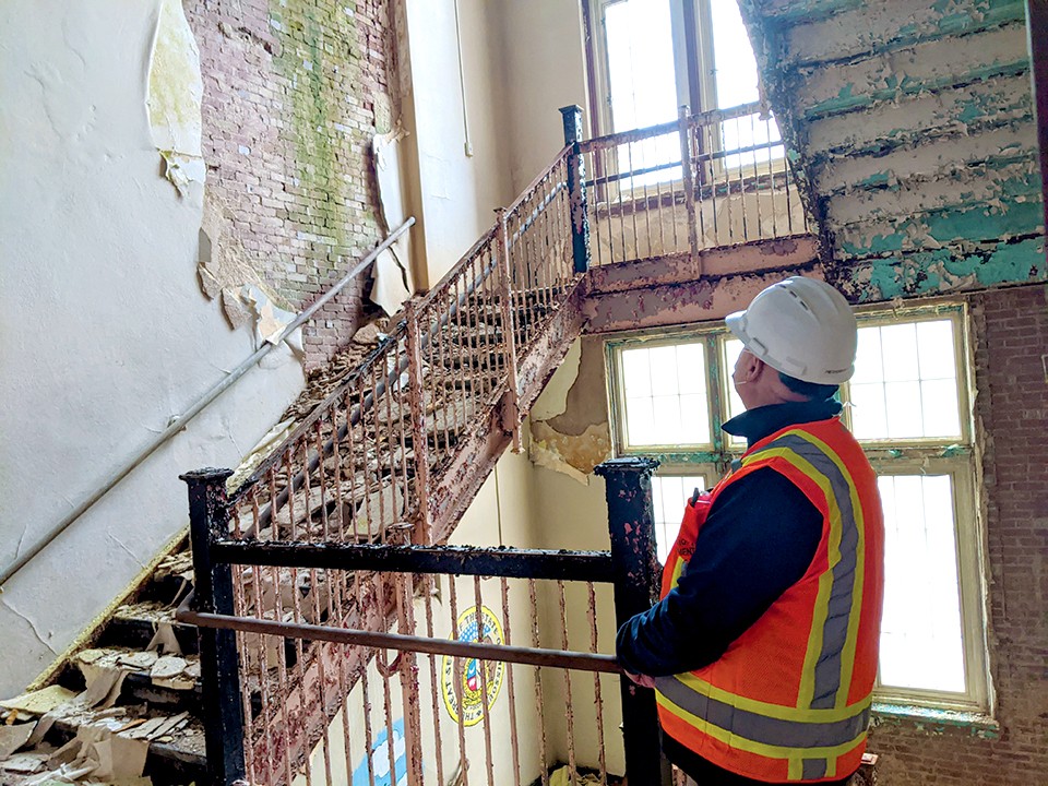 Bill Pietroburgo, an environmental engineer, observes the condition of a stairwell in Euclid School. - DANNY WICENTOWSKI
