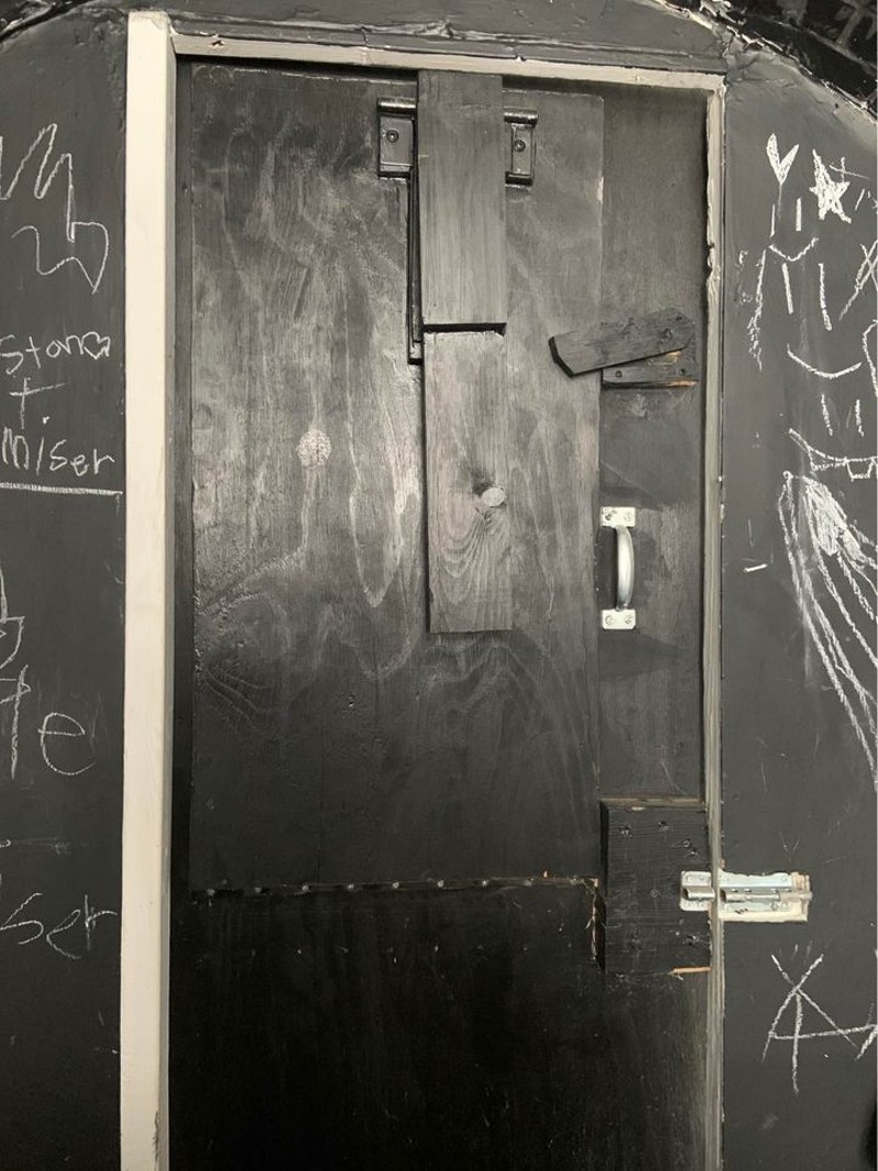 A view of the front door and chalkboard surfaces on the interior of the sewer pipe home. - JEANNE SPEZIA