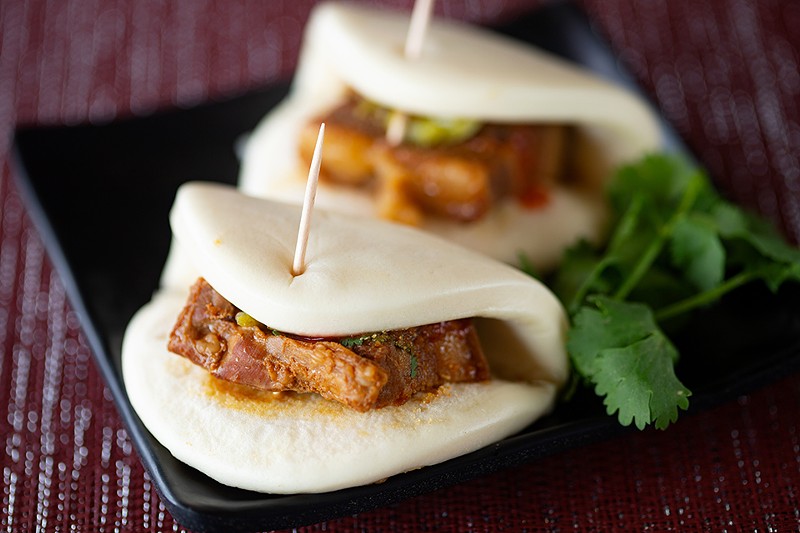 Gua bao (pork belly bun) is a Taiwanese street snack with a steamed bun, braised pork belly, cilantro, ground peanut, pickled mustard green and house sauce. - MABEL SUEN
