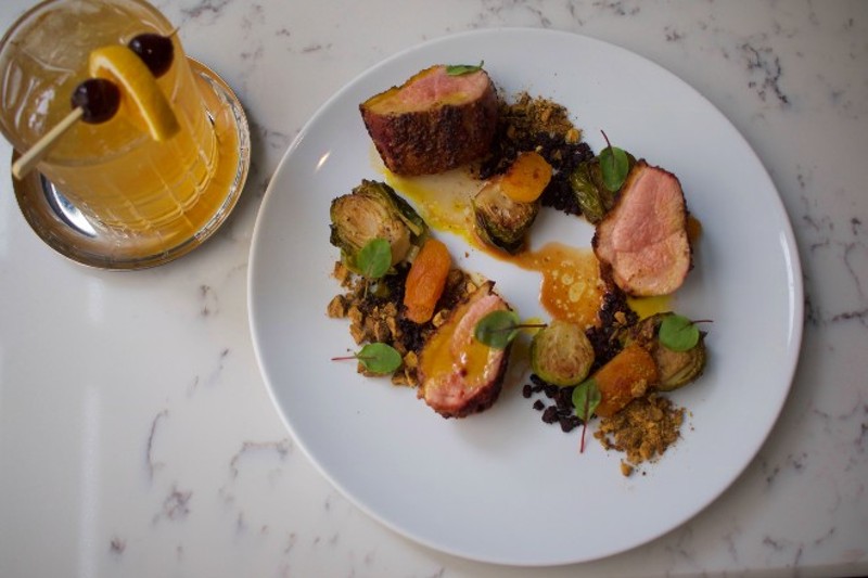Tandoor duck breast, Corrigan's favorite entree, features Brussels confit, apricot, cocoa soil and black lime pistachio. - CHERYL BAEHR