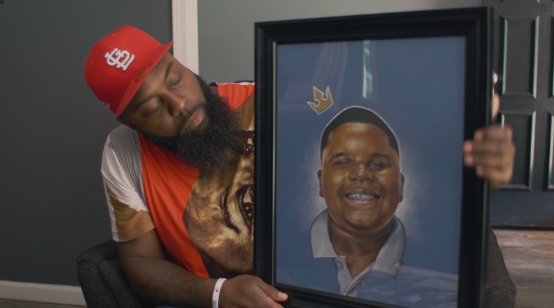 Michael Brown Sr. with a portrait of his son in a scene from Ferguson Rises. - FERGUSON RISES