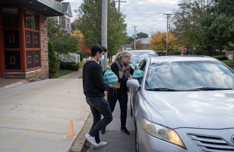 Volunteers deliver food to a car during a previous Drive-Thru Supper Club event. - WELCOME NEIGHBOR STL