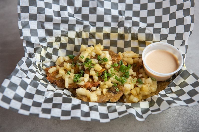 Tostones are topped with pineapple salsa and served with curry aioli. - Vu Phong