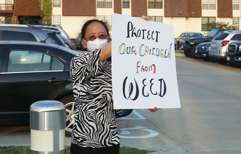 An Olivette resident protests a permit for a medical marijuana cultivation and production facility outside Olivette City Hall on Tuesday. - MONICA OBRADOVIC