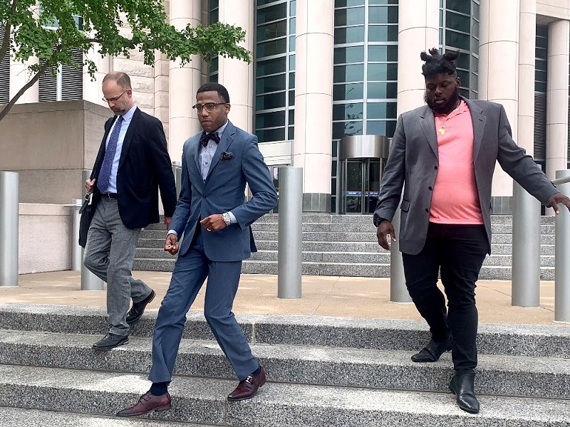 John Collins-Muhammad (center) exits the Thomas F. Eagleton U.S. Courthouse after a hearing on Thursday. - Monica Obradovic