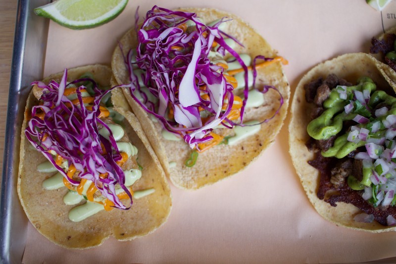 Tempura fish tacos are garnished with red cabbage, chipotle crema, jalapeño and cilantro. - CHERYL BAEHR