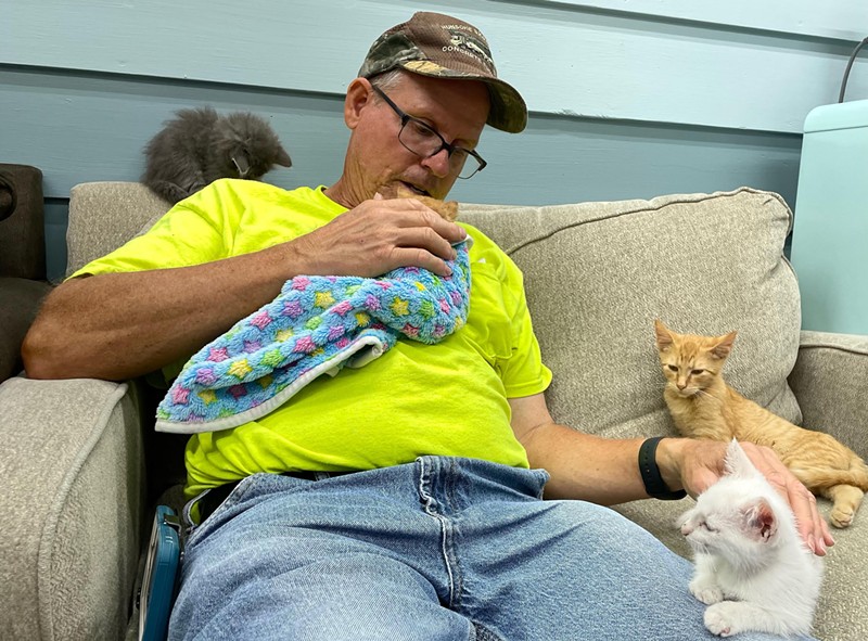 Tim, who helps run the cat rescue, Catty Shack, with his family, plays with some kittens. - VIA CATTY SHACK