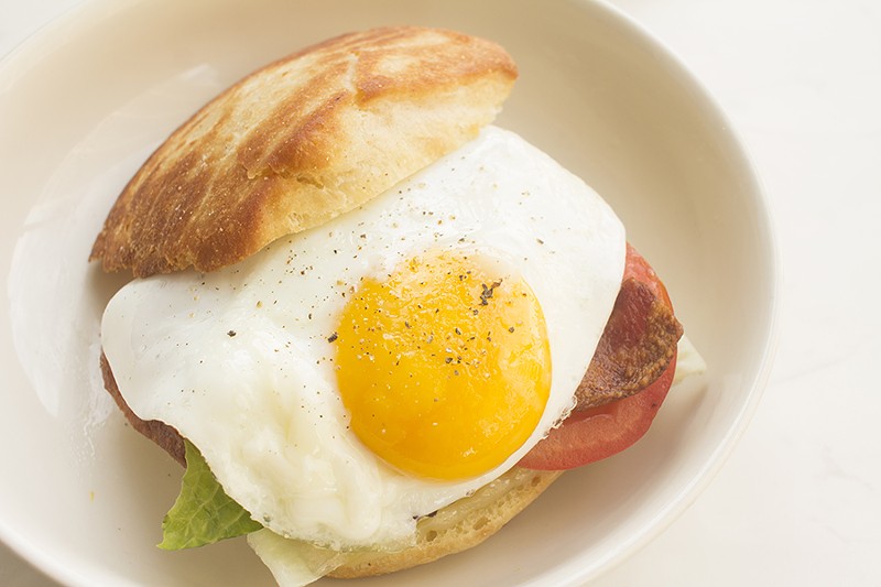 An English muffin sandwich with fried egg, bacon, Crystal aioli, red-pepper jelly and pepperjack. - PHOTO BY MABEL SUEN