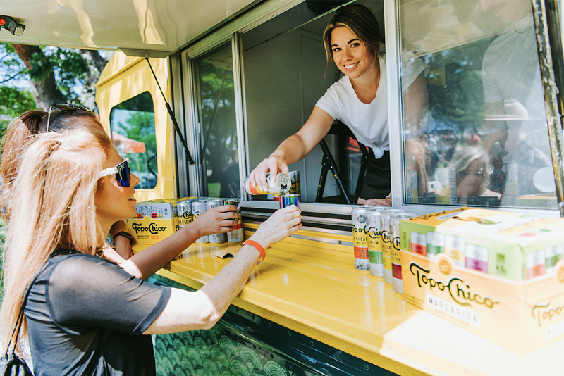 A woman sells Seltzer out of a food truck.