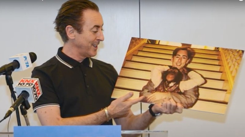 Alan Cumming holding a picture of his erstwhile co-star, Tonka.