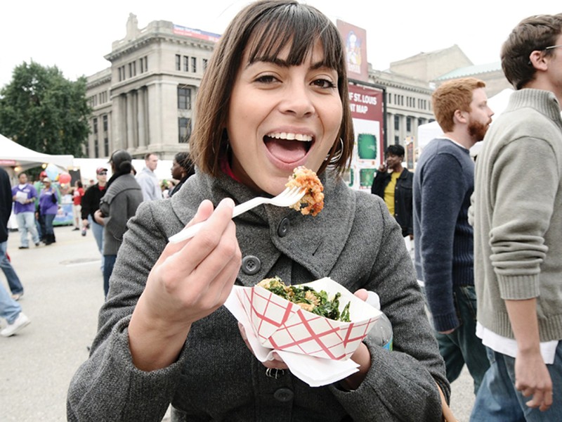 A woman smiles as she's about to take a bite of food at Taste of St. Louis.