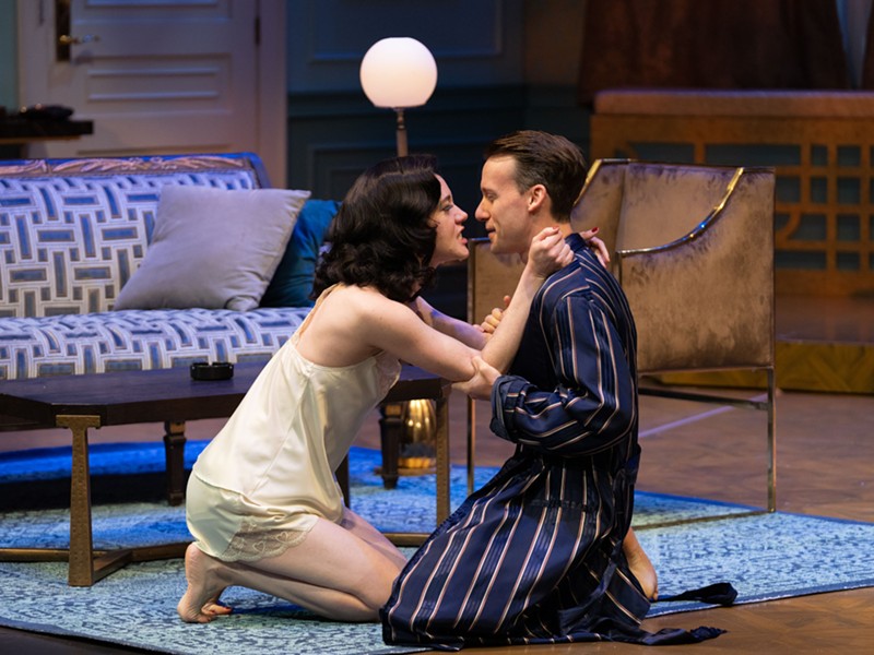 A woman and man, in 1930s lounge wear, embrace on the floor in a scene from Noel Coward’s Private Lives, at The Rep in St. Louis.