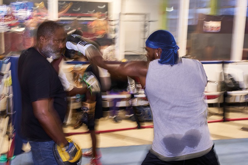 Brian Shaw trains his son, Stephan Shaw, in a boxing ring.