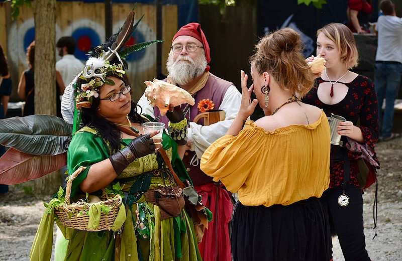 A group of people dressed in costume gather at the Renaissance Fair.