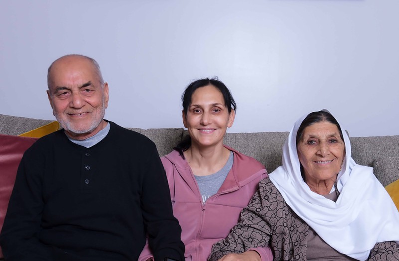 Mohammad Jan, BiBi Asifa Danishyar and Latifa Sidiqi sit on a couch in front of a blank wall.