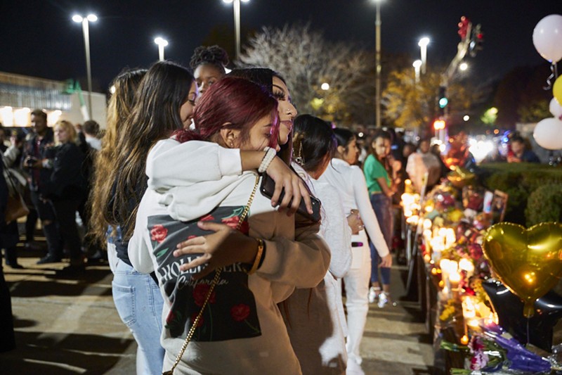 Students hug at a vigil after the shooting at Central Visual and Performing Arts High School. Politicians argue that teachers could protect students by carrying guns in the classroom.