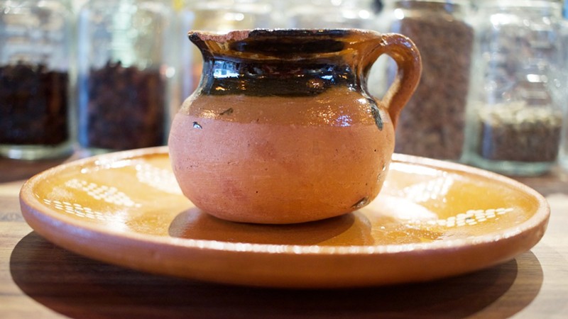 Mexican coffee is served in a traditional clay vessel.