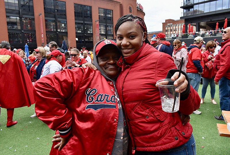Two people in red post for a picture outside of Busch Stadium.