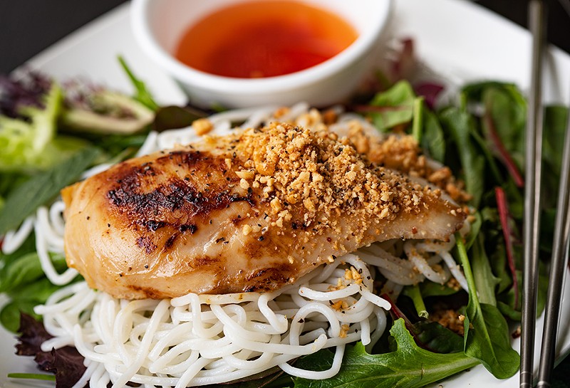 Chicken noodle salad is served with rice noodles, fresh vegetables and herbs.