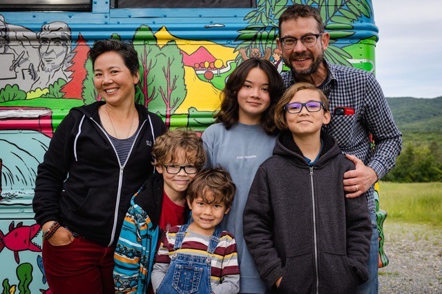 Robbi Behr, left, and Matthew Swanson, right, with their four kids and fellow road-trippers. - COURTESY OF BUSLOAD OF BOOKS