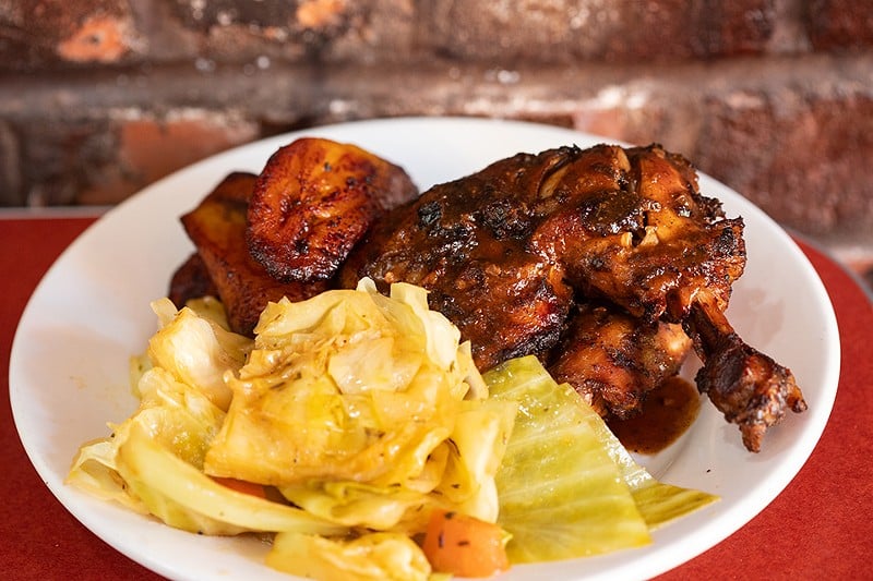 The jerk chicken is served with cabbage and sweet plantain.