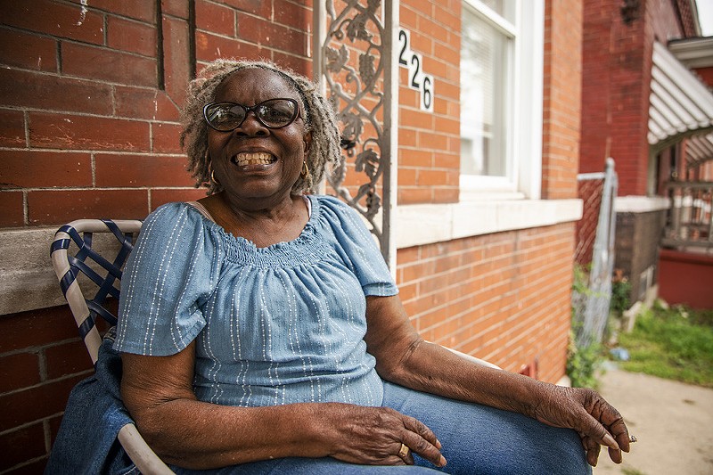 Anita Monroe laughs on her front porch. Monroe lives a few blocks from the Eliot School and is positive about the plans for the site. - ZACHARY LINHARES