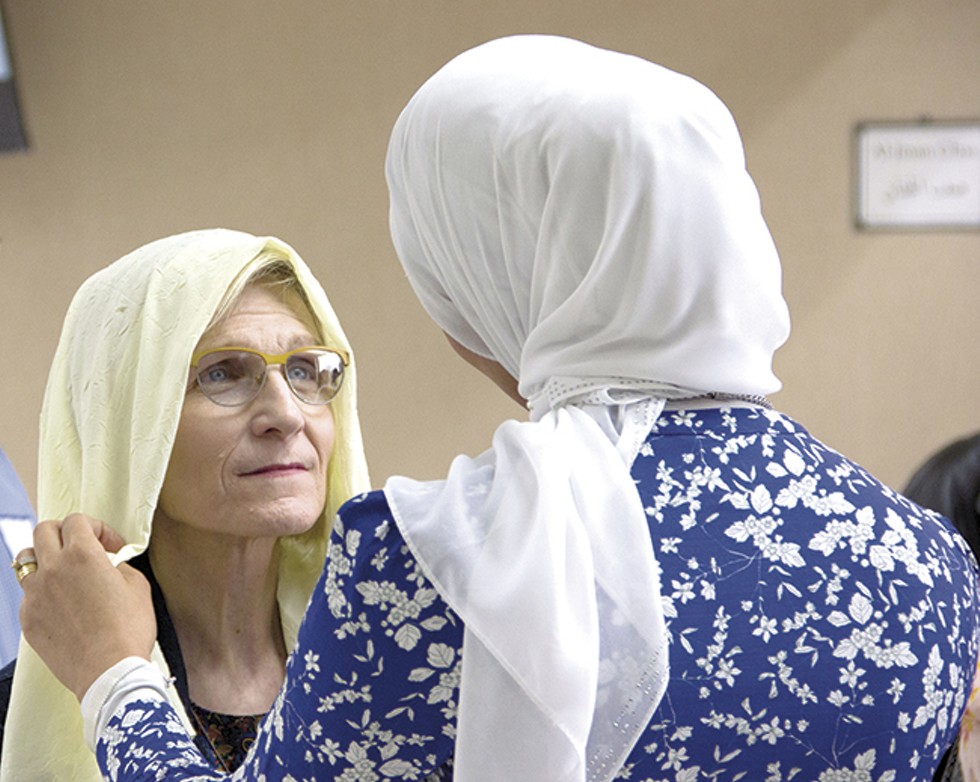 A visitor tries on a headscarf during CAIR-Missouri's March 26 "Make America Whole Again" open house. - PHOTO BY DANNY WICENTOWSKI