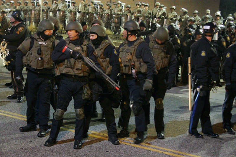 The Missouri National Guard stand in front of the Ferguson Police Department in 2014. - PHOTO BY DANNY WICENTOWSKI