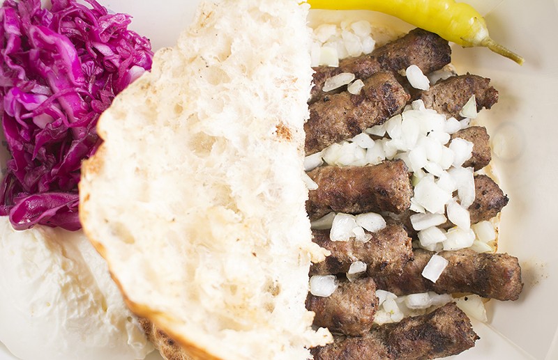 The Bosnian sausage cevapi is served with kajmak and ajvar on flatbread. - MABEL SUEN