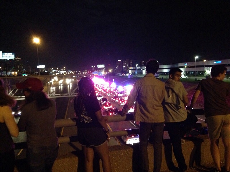 Bystanders watch from the bridge over I-64 as protesters march along the highway. - DOYLE MURPHY