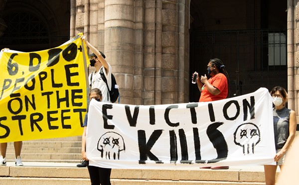 Protesters hold up banners outside City Hall on August 2, 2021.