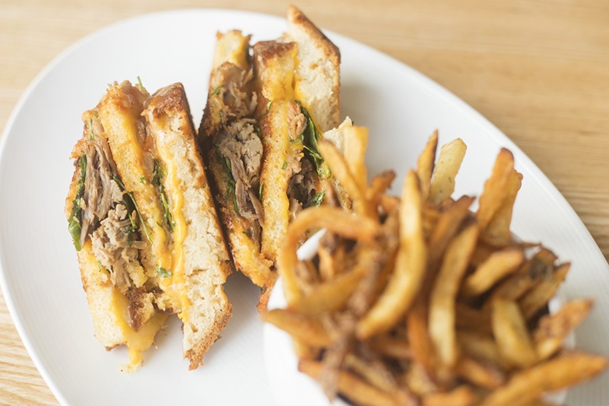 Pangea's terrific duck grilled cheese is topped with arugula and tomato jam and served with seasoned fries.