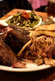 A combo plate with pulled pork, brisket and ribs with tangy slaw and roasted green beans with tomatoes.