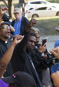 State Representative Bruce Franks Jr. leads protesters in a chant on the steps of St. Louis City Hall.
