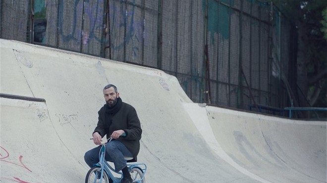 Aris attempts to recapture his memory by completing a series of human milestones, including riding a child's tiny two-speed at a skate park, and documenting them with a Polaroid camera.