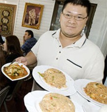 JENNIFER SILVERBERG - Simply Thai co-owner Scott Truong shows just a few of the 100 options on the menu.