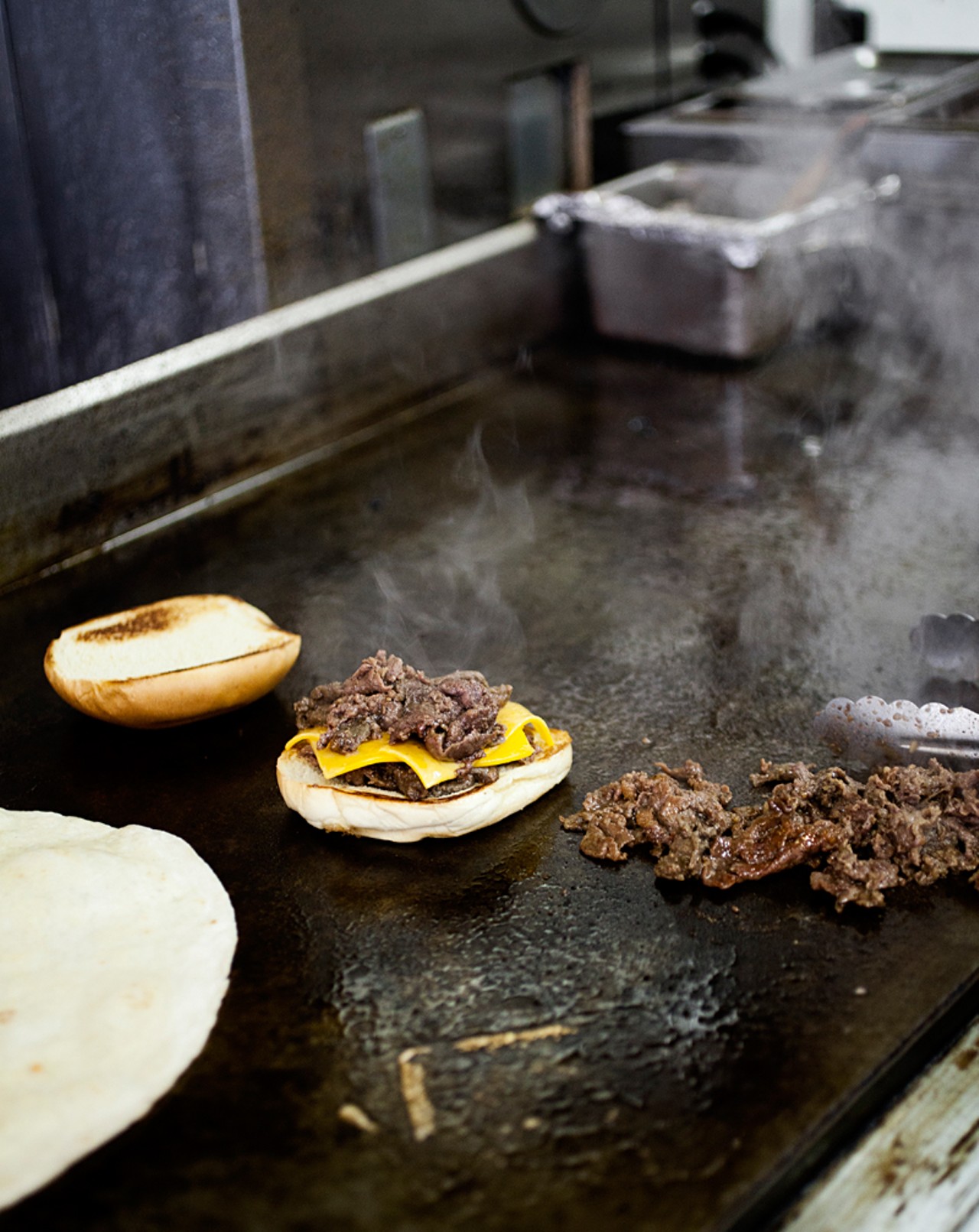The rib-eye steak Kim Cheese burger on the grill.