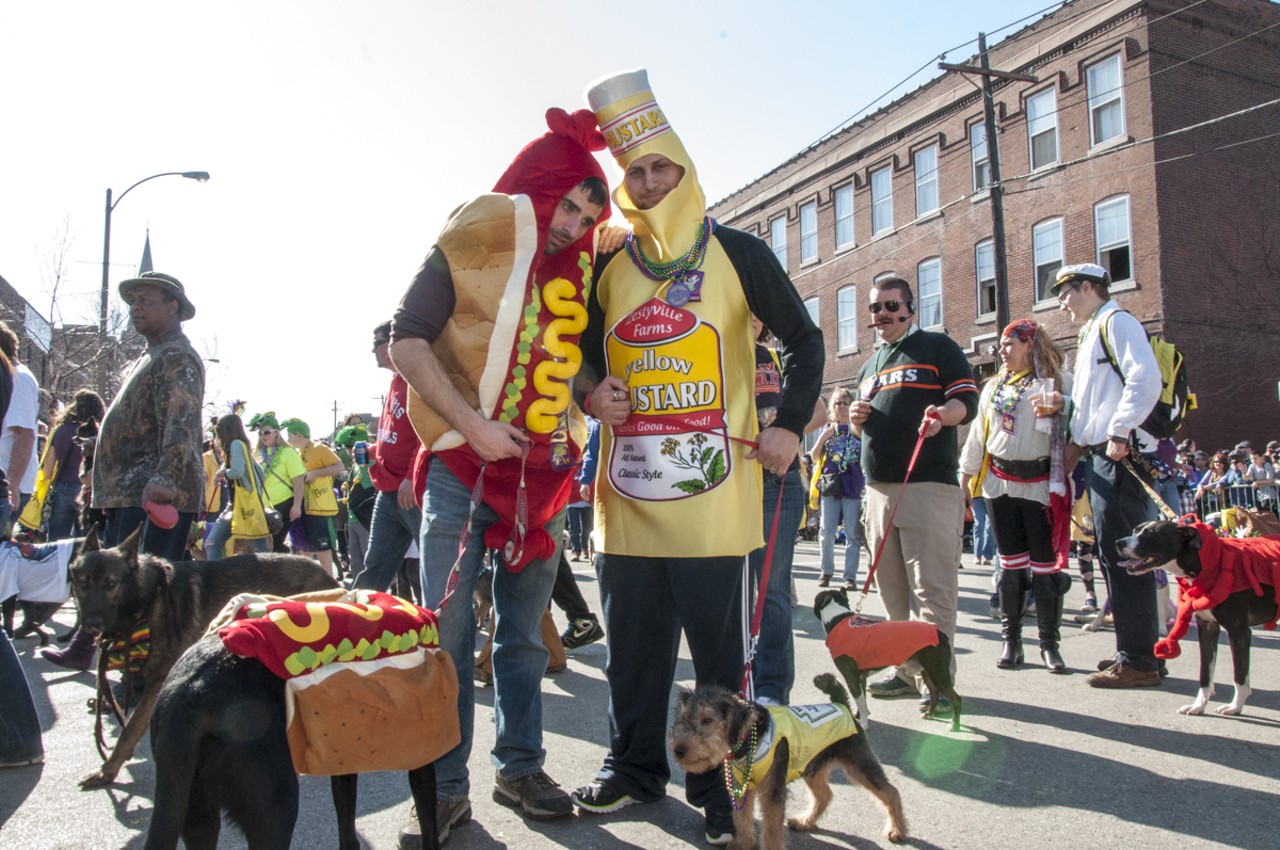 Tyler and Spencer walking their dogs Coltraine and Barley in matching hot dog and mustard costumes.