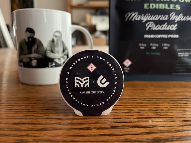 Missouri’s Own Edibles’ new marijuana-infused coffee pod in front of a mug and a bag that they came in.