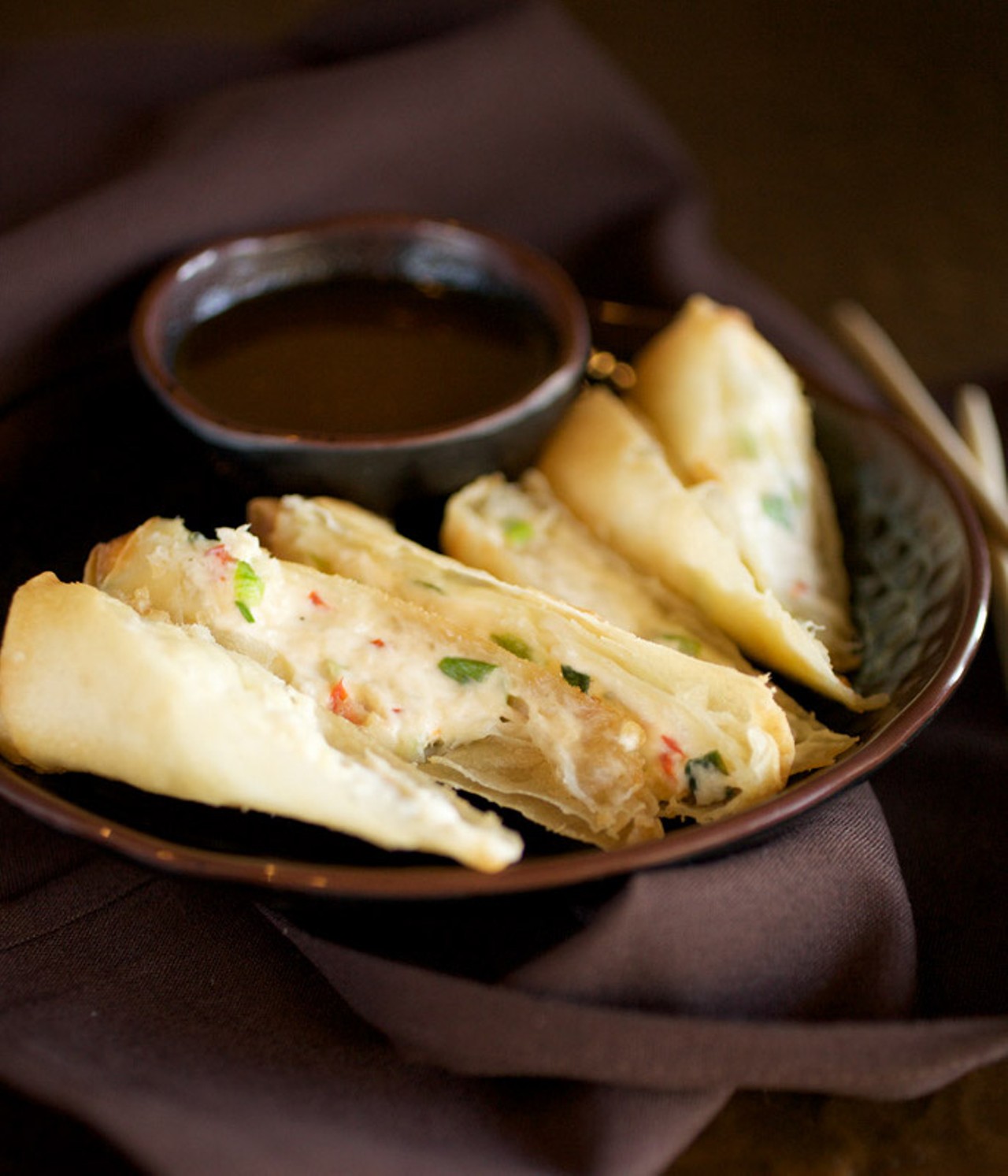 The house made, hand rolled, crab rangoon is made with real lump crab meant, bell peppers, scallions and ginger. It is served with their house made soy mustard sauce.