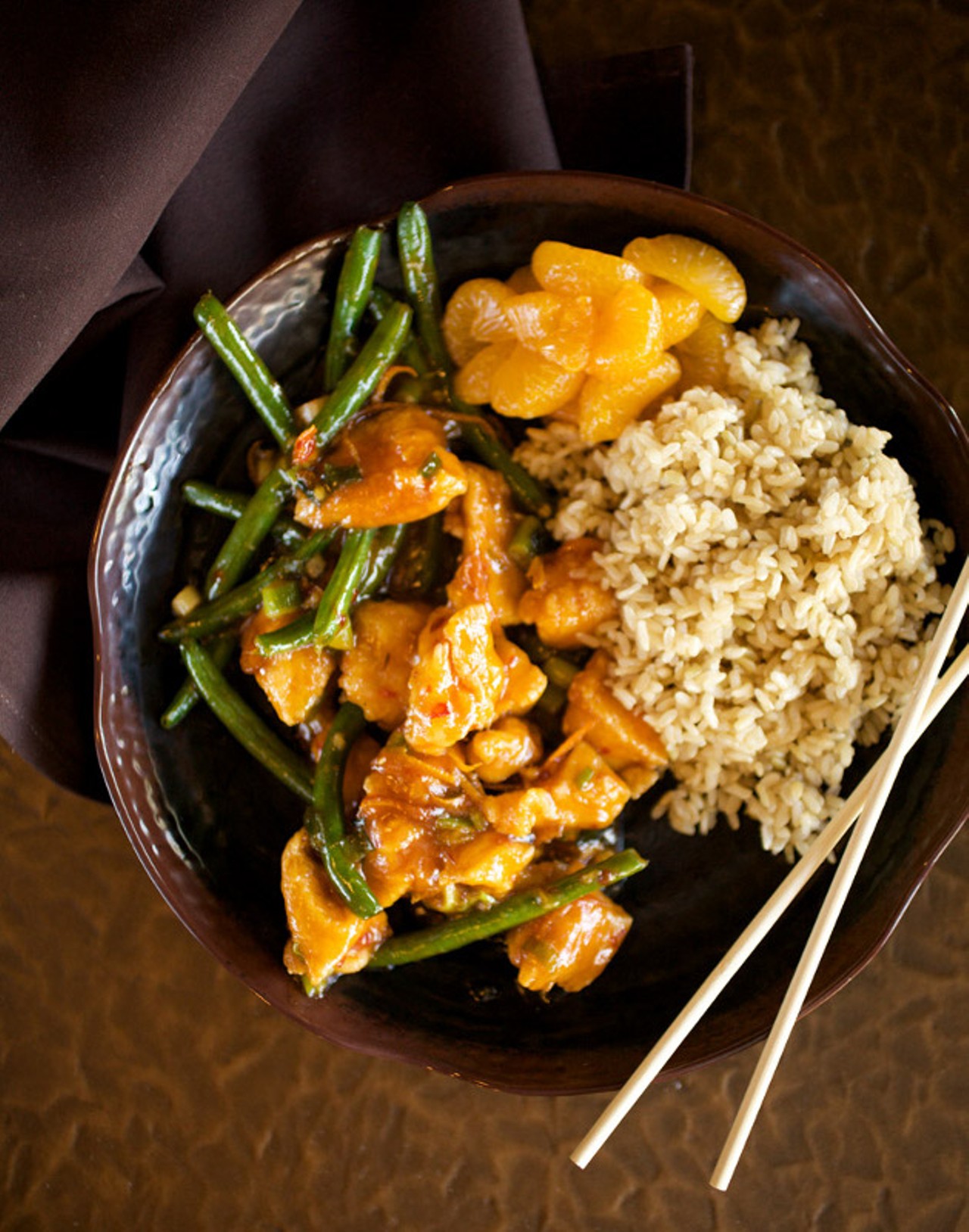 The Honey Orange entree comes with your choice of chicken, beef, shrimp, vegetable or tofu, as well as your choice of white or brown rice. Shown here with chicken, it is prepared with sweet orange ginger sauce tossed with green beans and served with a side of mandarin oranges.